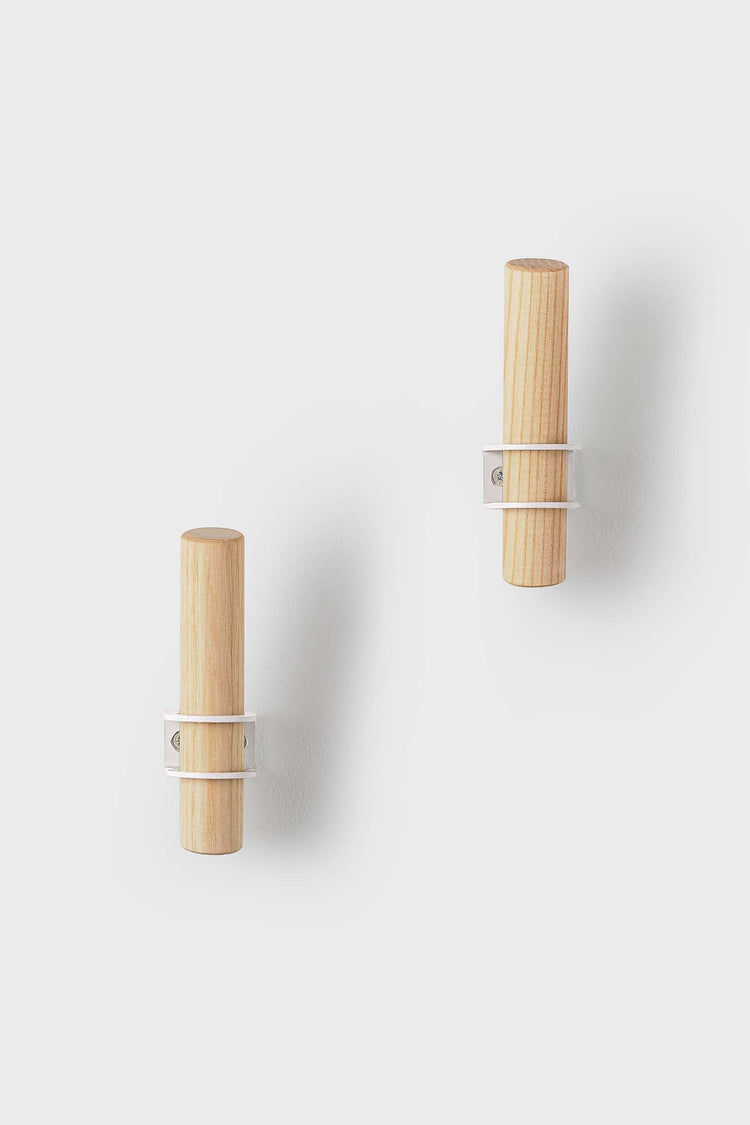 Torch-inspired decorative wall hooks made of ash wood and metal, designed by Tore Bleuzé, ideal for stylish and functional home storage