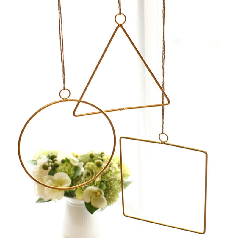 Gold geometric hanging decor made from metal, perfect for modern interiors or event styling with flowers and lights