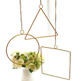 Gold geometric hanging decor made from metal, perfect for modern interiors or event styling with flowers and lights