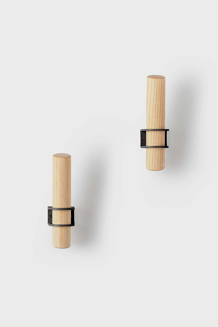 Torch-inspired decorative wall hooks made of ash wood and metal, designed by Tore Bleuzé, ideal for stylish and functional home storage