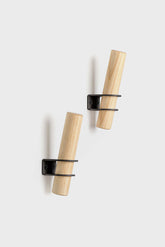 Torch-inspired decorative wall hooks made of ash wood and metal, designed by Tore Bleuzé, ideal for stylish and functional home storage