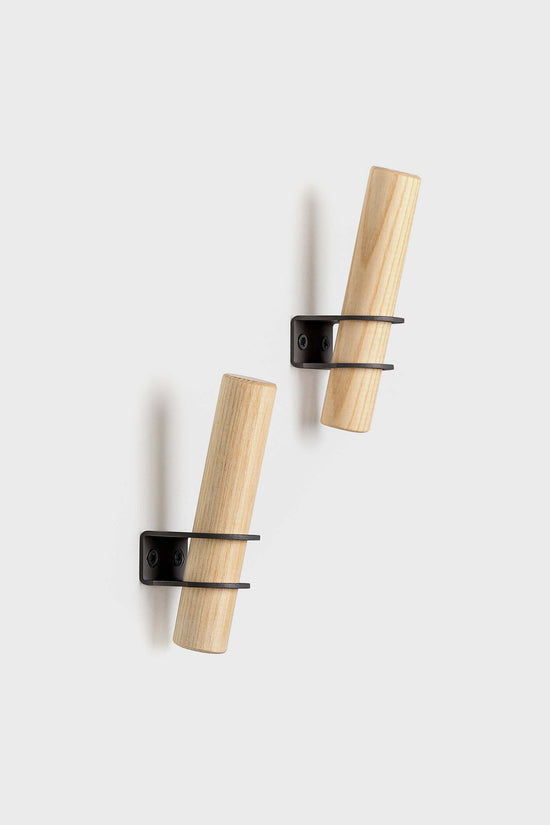 Torch-inspired decorative wall hooks made of ash wood and metal, designed by Tore Bleuzé, ideal for stylish and functional home storage