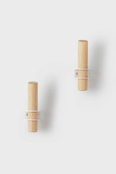 Torch-inspired decorative wall hooks made of ash wood and metal, designed by Tore Bleuzé, ideal for stylish and functional home storage